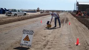 A regulator inspects a nuclear gauge used on pavement to assess quality and density